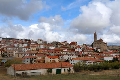 Houses in town against cloudy sky
