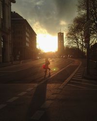 Woman on road in city at sunset