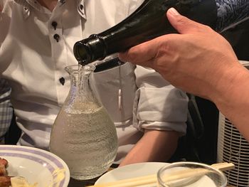 Midsection of man drinking beer in glass