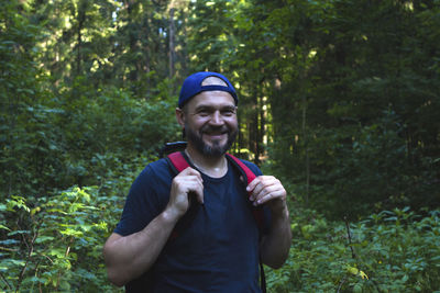 Portrait of smiling man standing in forest