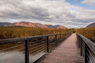 View of boardwalk on landscape against sky