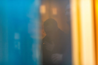 Portrait of man standing against window