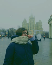 Portrait of man standing in city during winter