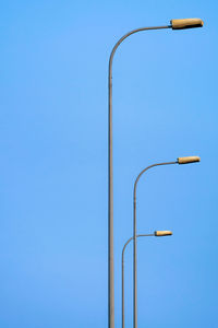 Low angle view of street light against blue sky