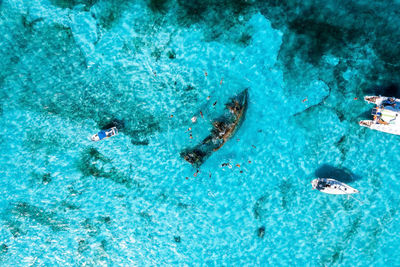 People snorkelling around the ship wreck near cancun in the caribbean sea.