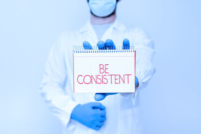 Digital composite image of doctor holding dentures in laboratory