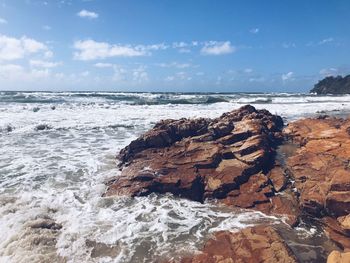 Rocks in sea against sky