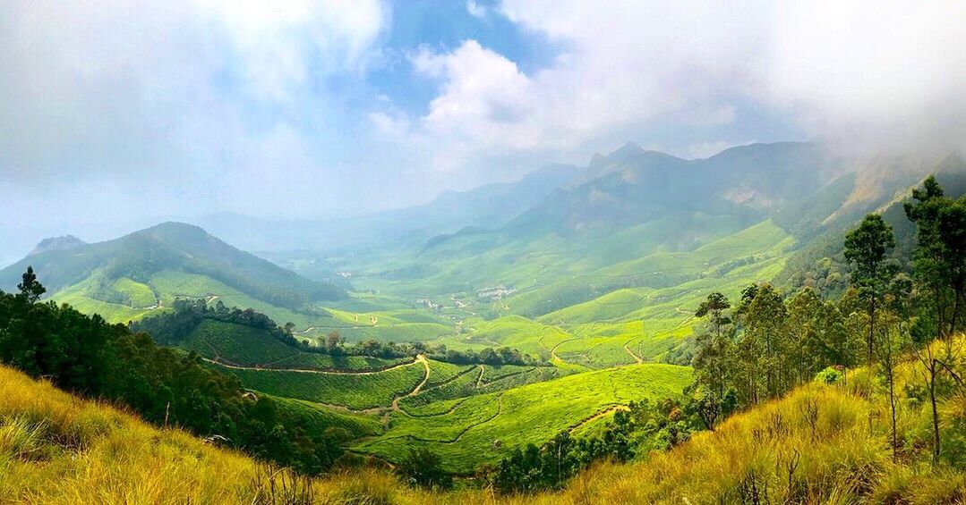 SCENIC VIEW OF AGRICULTURAL FIELD AGAINST MOUNTAINS