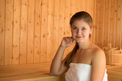 Beautiful young woman relaxing in sauna