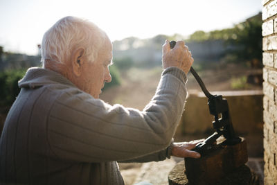 Senior man using an old tool for cracking walnuts