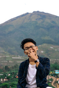 Portrait of young man standing on mountain