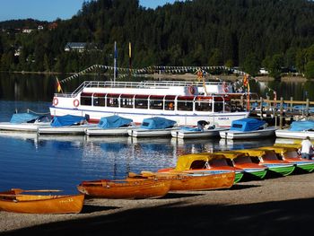 Boats moored in lake against trees