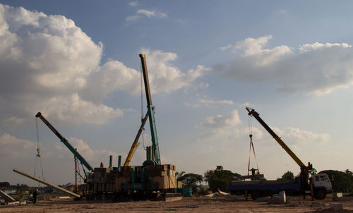 Cranes at construction site against sky