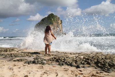 Full length of man standing on beach against sky