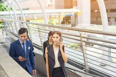 People on elevated walkway in city