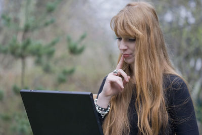 Young woman using laptop outdoors