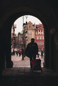 Rear view of people walking in tunnel