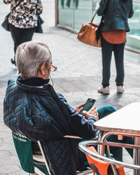 Rear view of man and woman standing on mobile phone