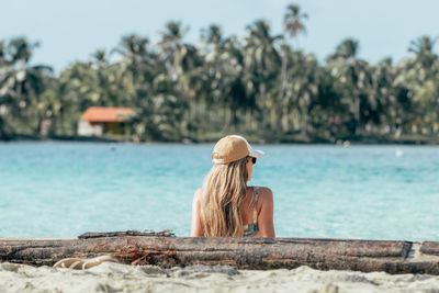 Rear view of woman standing by lake