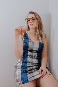 Midsection of young woman drinking glass