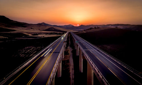 High angle view of illuminated road against sky during sunset