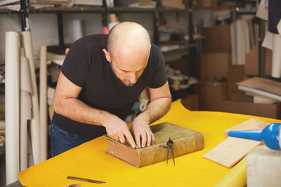 Man working on book at workshop