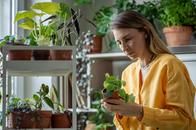 Young woman holding potted plant