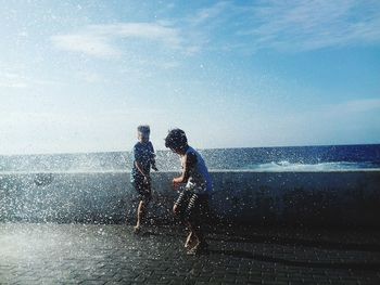 People on beach against sky