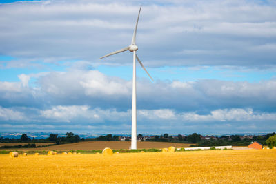 Scenic view of field against cloudy sky