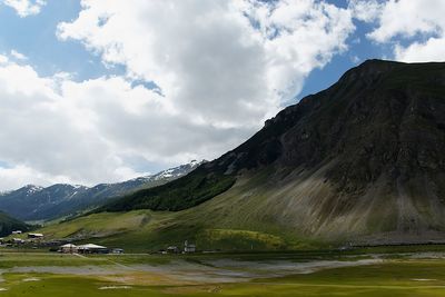 Scenic view of lake by mountains against sky