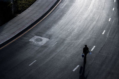 High angle view of man walking on road