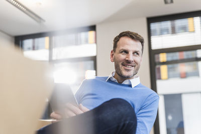 Smiling businessman using tablet in office