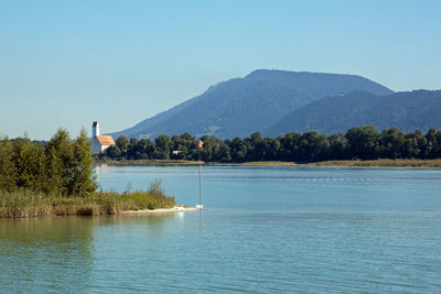 Scenic view of lake and mountains against clear sky