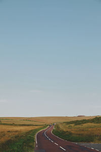 Empty road along countryside landscape