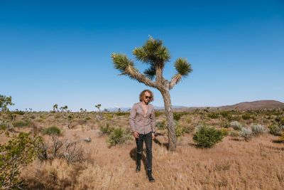 Portrait of man on field against clear sky