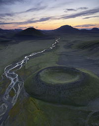 River and crater in evening in highlands