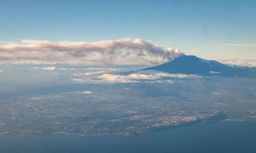 Aerial view of snowcapped mountains against cloudy sky