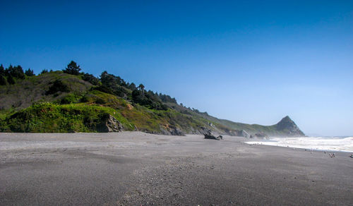 Scenic view of beach against blue sky