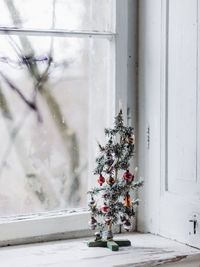 Close-up of small christmas tree on window sill at home
