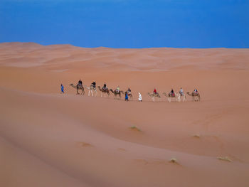 Group of people on sand dune