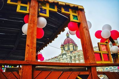 Low angle view of balloons on building against sky