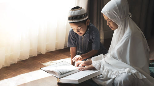 Father and girl reading book