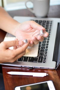 Midsection of woman using smart phone on table