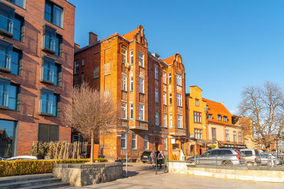 Buildings in city against clear blue sky