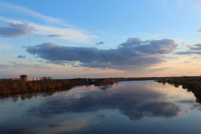 Scenic view of lake in city against sky during sunset