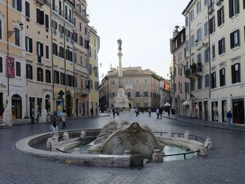 People on street by buildings in city