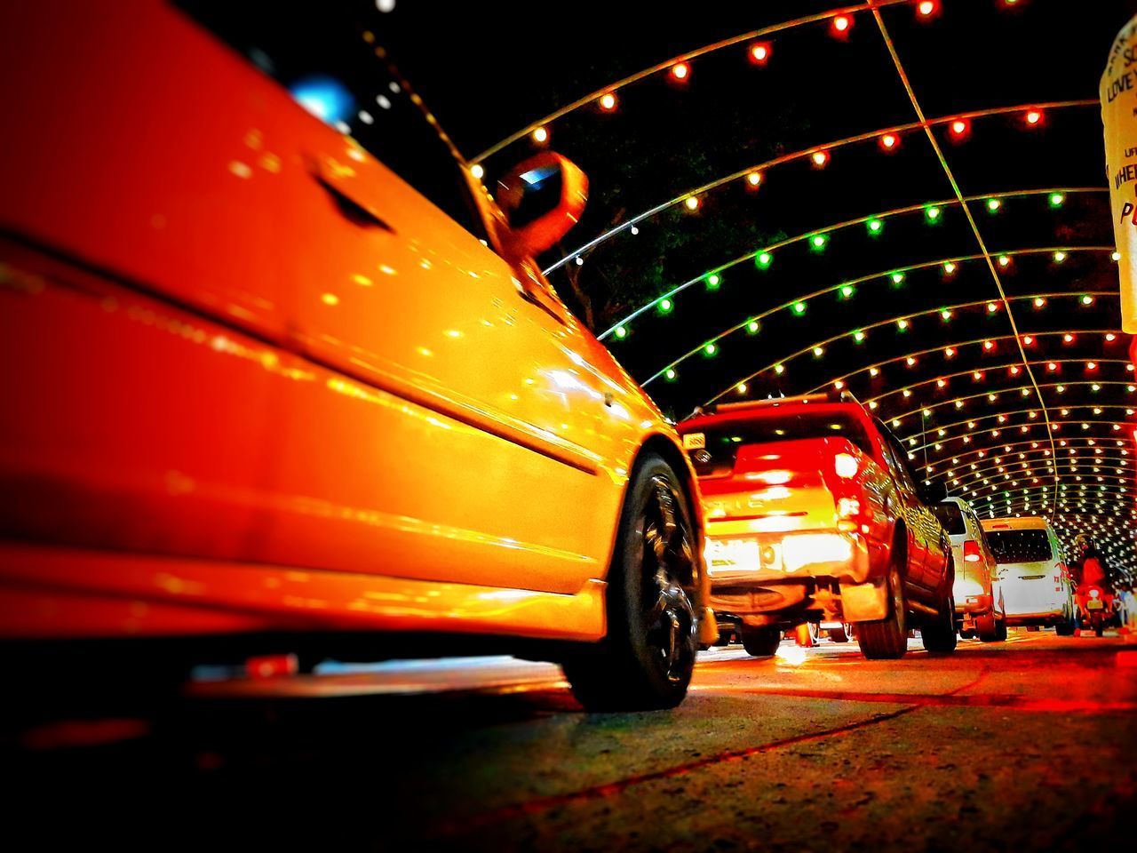CARS IN ILLUMINATED CITY AT NIGHT