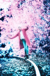 Woman standing by pink tree