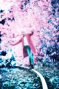 Full length of woman with arms outstretched standing at park