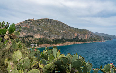 Scenic view of sea and mountains against sky